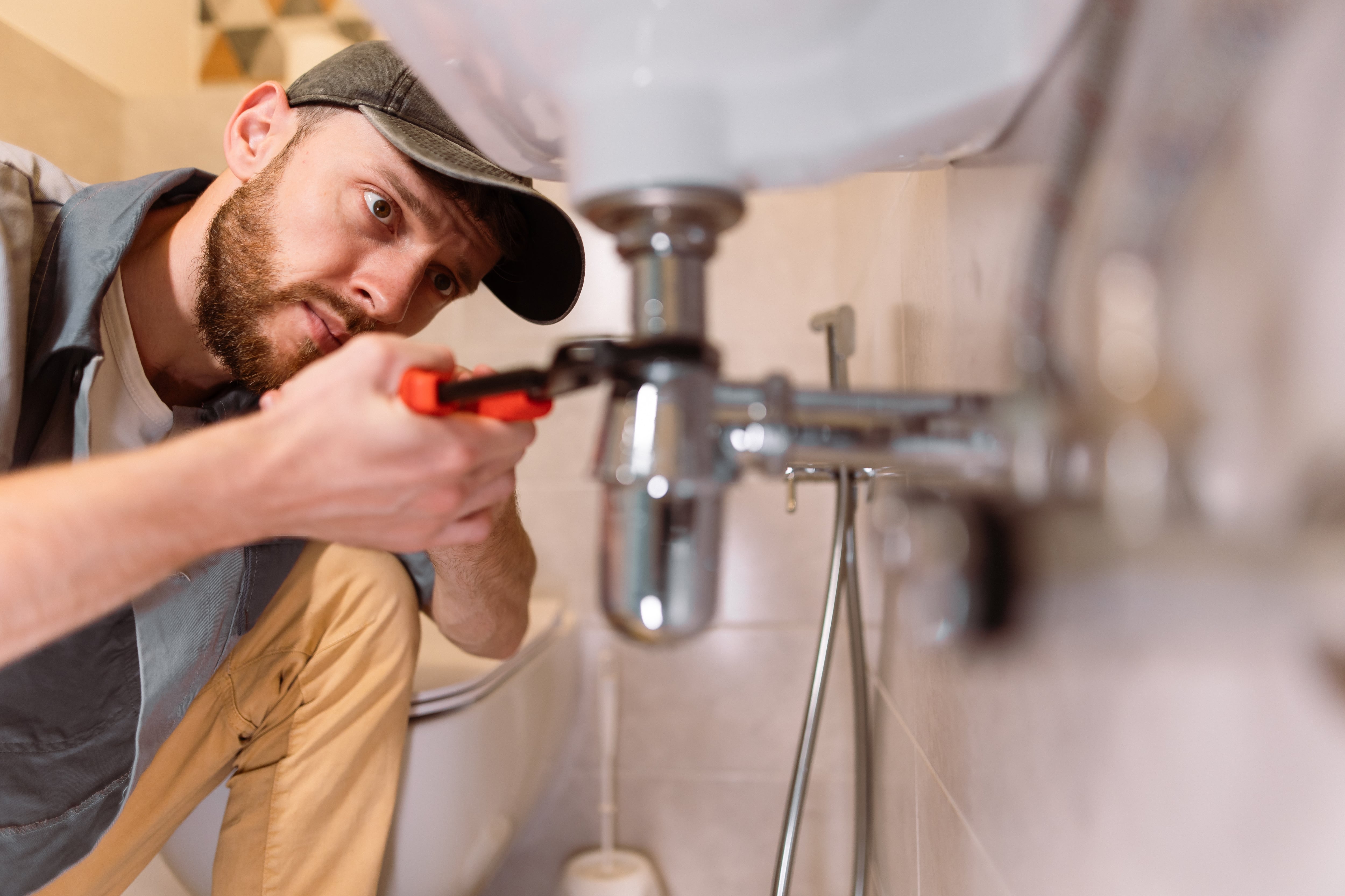 Hombre arreglando fuga del lavamanos dentro de una vivienda / Foto: GettyImages
