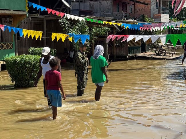 BOG700. ALTO BAUDÓ. (COLOMBIA), 11/11/2024.- Fotografía cedida por el ejército de Colombia que muestra un soldado con tres personas en una calle inundada, este lunes en Alto Baudó (Colombia). El Ejército de Colombia entregó este lunes más de 300 kits de ayuda humanitaria en el departamento colombiano del Chocó, en la costa Pacífica, donde más de 100.000 personas resultaron damnificadas por las fuertes lluvias e inundaciones que durante el fin de semana afectaron a 25 municipios de esta región. EFE/Ejército de Colombia /SOLO USO EDITORIAL/SOLO DISPONIBLE PARA ILUSTRAR LA NOTICIA QUE ACOMPAÑA (CRÉDITO OBLIGATORIO)
