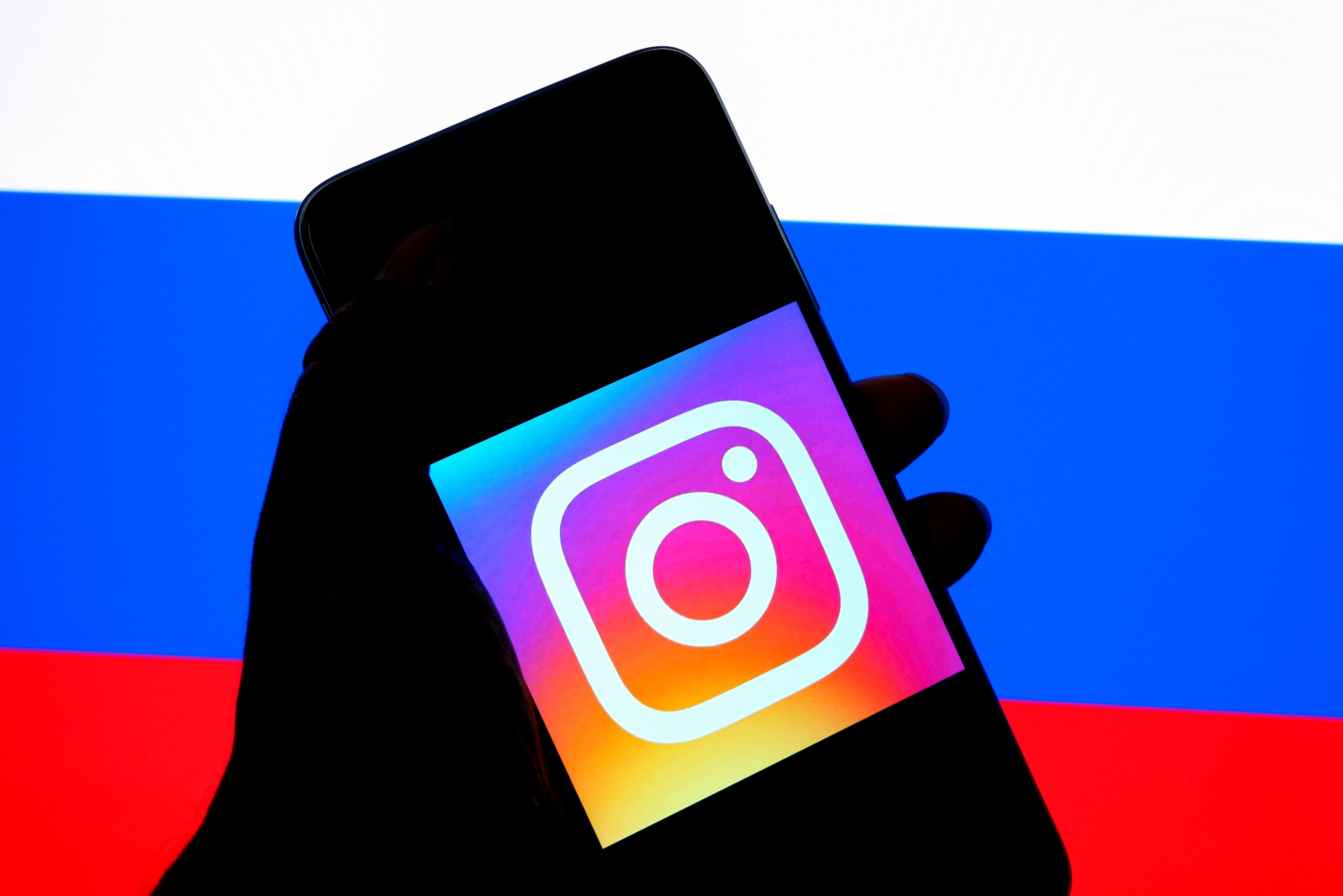 INDIA - 2022/03/06: In this photo illustration an Instagram logo seen displayed on a smartphone with a Russian Flag in the background. (Photo Illustration by Avishek Das/SOPA Images/LightRocket via Getty Images)