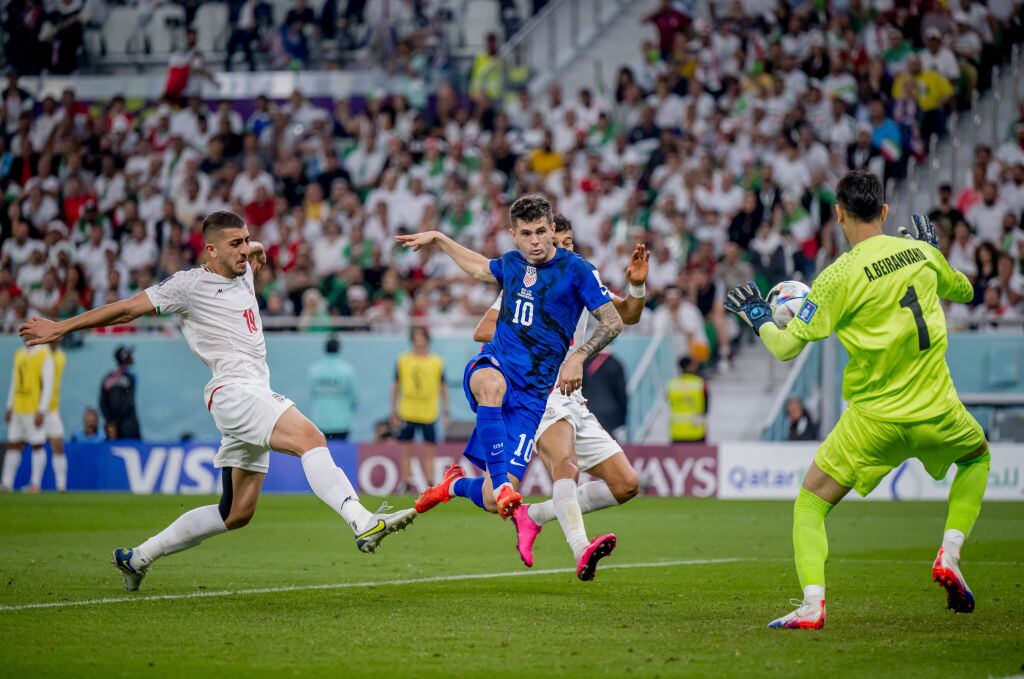 DOHA, QATAR - NOVEMBER 29: Christian Pulisic (C) of USA scores his team's first goal past Majid Hosseini (L), Alireza Beiranvand (R) and Amir Abedzadeh of Iran during the FIFA World Cup Qatar 2022 Group B match between IR Iran and USA at Al Thumama Stadium on November 29, 2022 in Doha, Qatar. (Photo by Marvin Ibo Guengoer - GES Sportfoto/Getty Images)