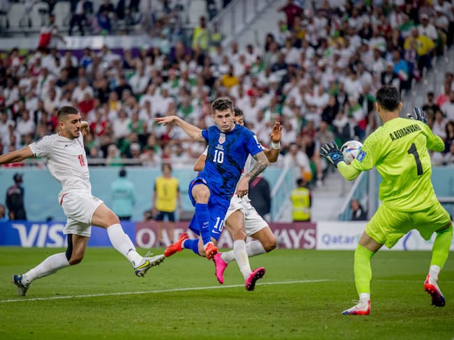 DOHA, QATAR - NOVEMBER 29: Christian Pulisic (C) of USA scores his team&#039;s first goal past Majid Hosseini (L), Alireza Beiranvand (R) and Amir Abedzadeh of Iran during the FIFA World Cup Qatar 2022 Group B match between IR Iran and USA at Al Thumama Stadium on November 29, 2022 in Doha, Qatar. (Photo by Marvin Ibo Guengoer - GES Sportfoto/Getty Images)