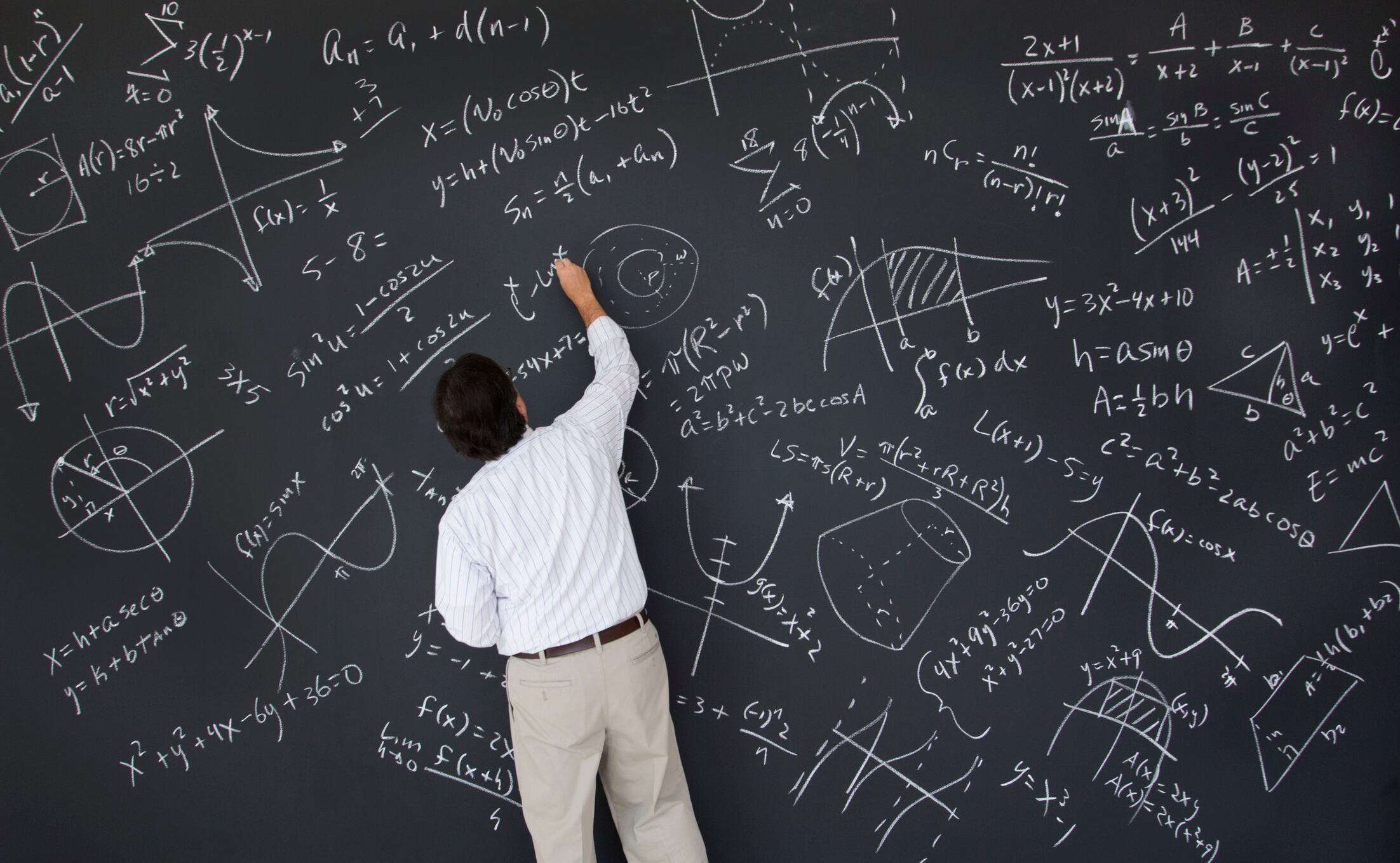 Forty nine year old math teacher writes equations during class.