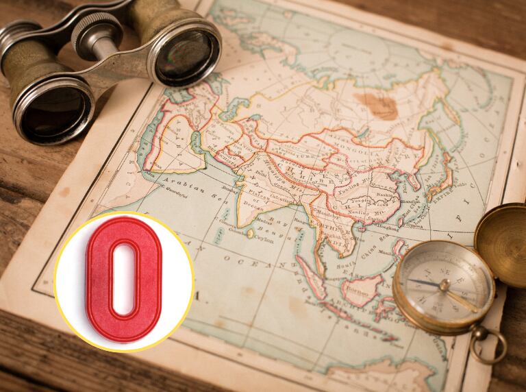 Mapa antiguo de Asia sobre una mesa, con binoculares y con brújula / Letra O (Getty Images)