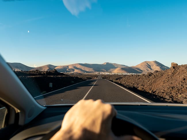 Imagen referencia de una persona conduciendo por carretera (GettyImages)