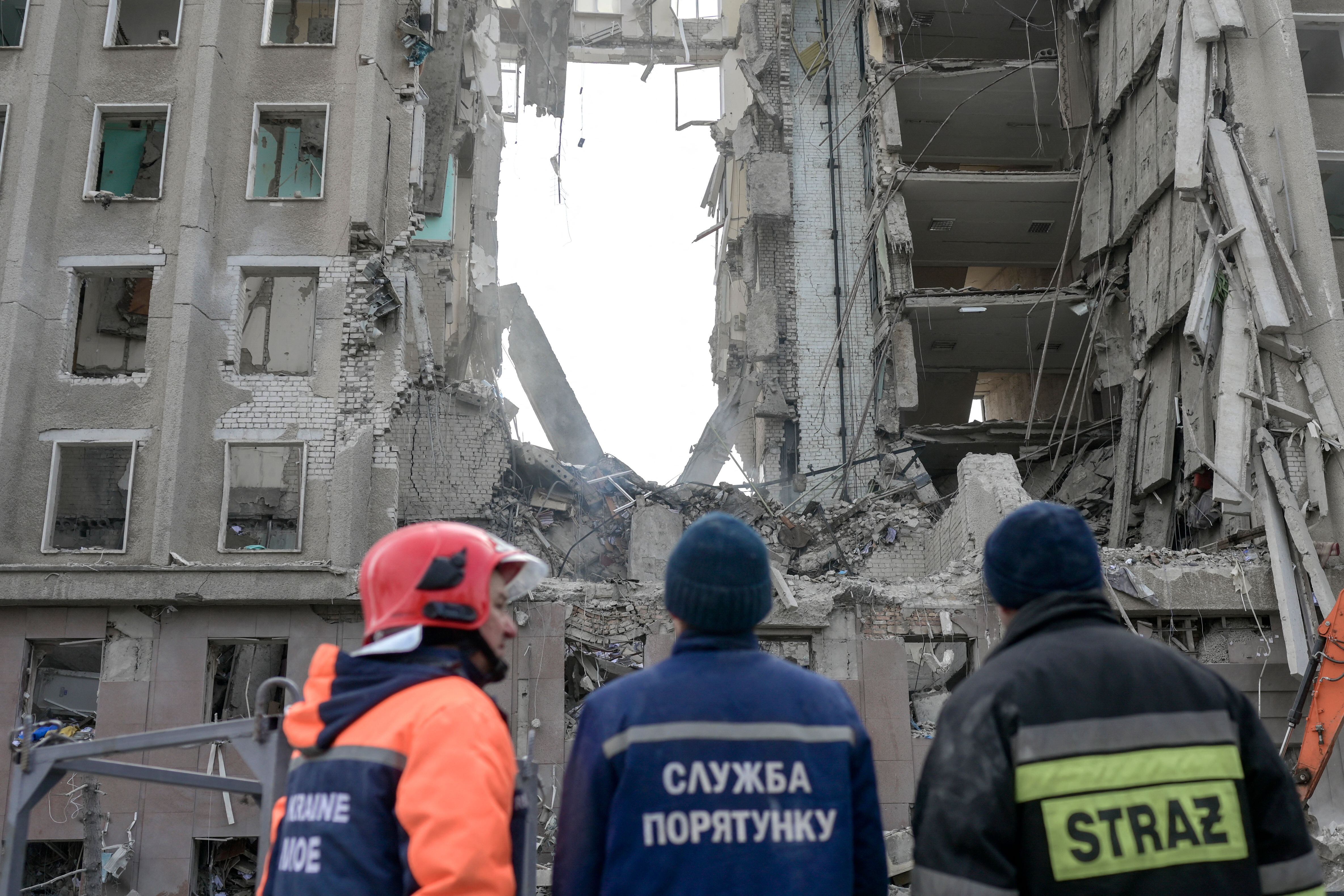 Rescue workers look at the rubble of government building hit by Russian rockets in Mykolaiv on March 29, 2022. - A Russian strike battered the regional government building in the southern Ukrainian city of Mykolaiv, a key port under heavy assault for weeks, the regional governor said on March 29, 2022. Governor Vitaly Kim said that most people inside the building had not been injured but several civilians and soldiers were unaccounted for. (Photo by BULENT KILIC / AFP) (Photo by BULENT KILIC/AFP via Getty Images)