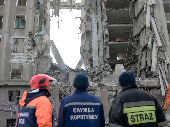 Rescue workers look at the rubble of government building hit by Russian rockets in Mykolaiv on March 29, 2022. - A Russian strike battered the regional government building in the southern Ukrainian city of Mykolaiv, a key port under heavy assault for weeks, the regional governor said on March 29, 2022. Governor Vitaly Kim said that most people inside the building had not been injured but several civilians and soldiers were unaccounted for. (Photo by BULENT KILIC / AFP) (Photo by BULENT KILIC/AFP via Getty Images)