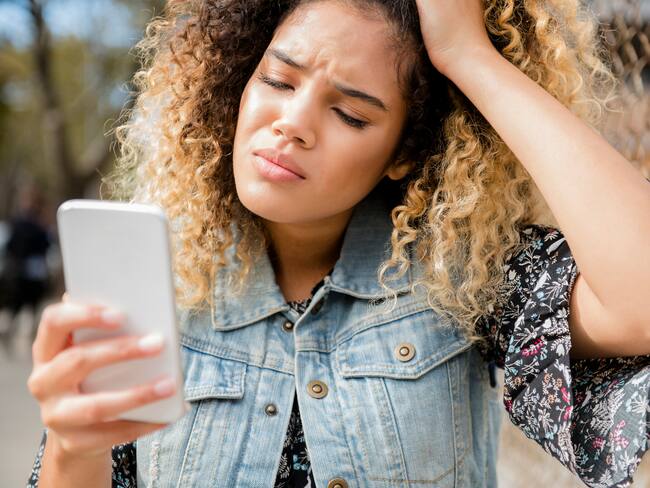 Unhappy Mixed Race woman texting on cell phone