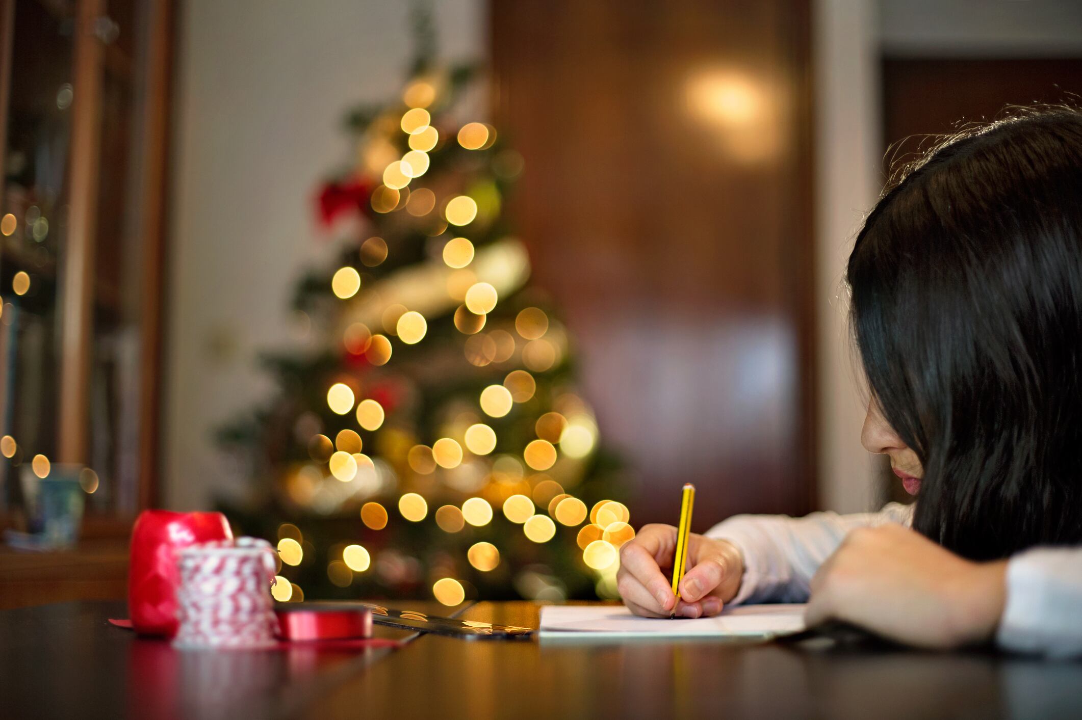 Cozy image of a young girl writing a letter to Santa Clauss or the three kings.Carta a los Reyes Magos o Papá Noel.