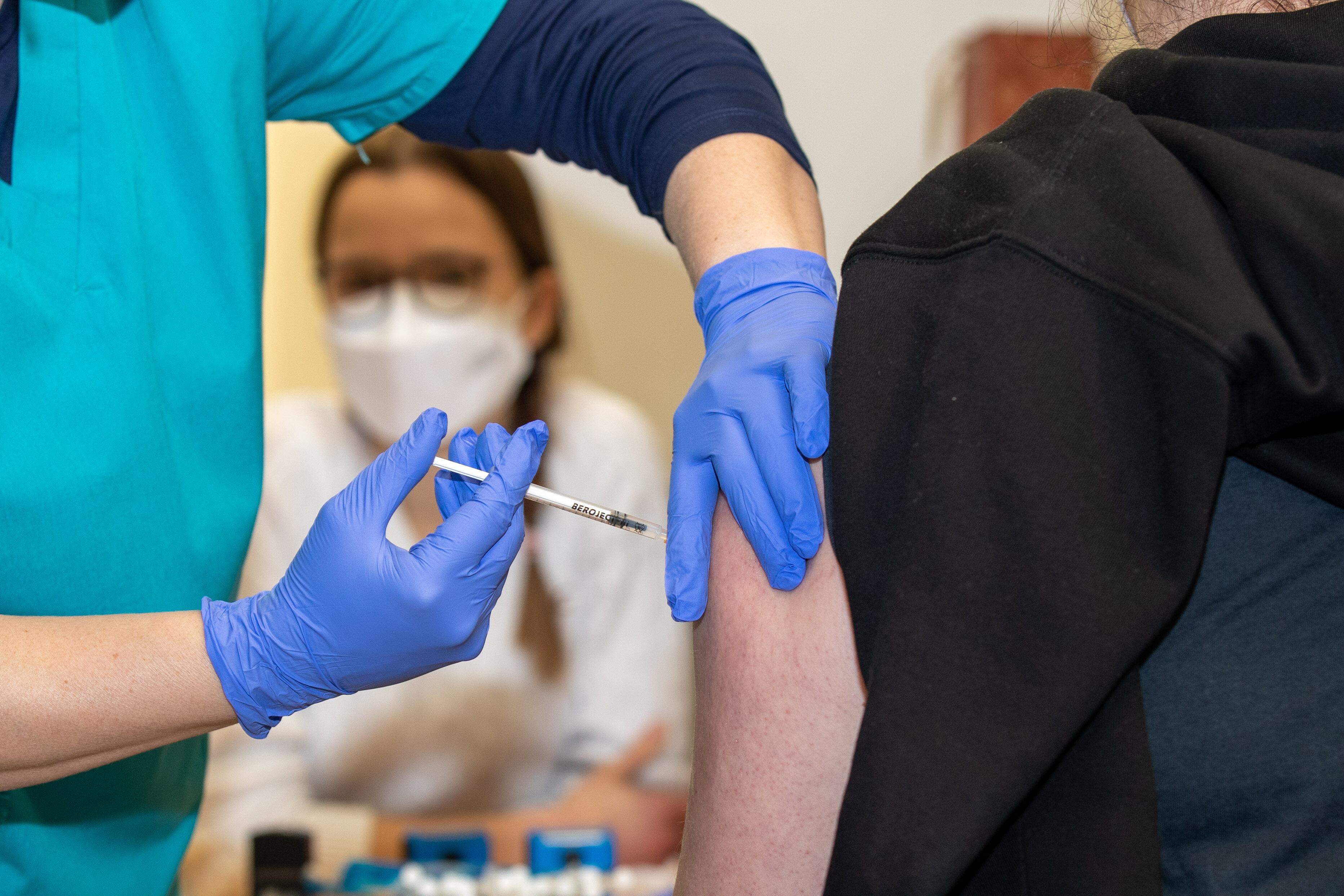 18 December 2021, Saxony, Dresden: Dresden doctor Tina Neumann (l) vaccinates a young woman with Moderna's mRNA vaccine at the Dresden State Art Collections. The vaccination rate in Saxony is the lowest in Germany. Photo: Daniel Schäfer/dpa-Zentralbild/dpa (Photo by Daniel Schäfer/picture alliance via Getty Images)