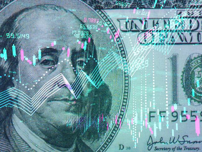 Billete de 100 dólares estadounidense con gráfico de indicadores económicos (Getty Images)