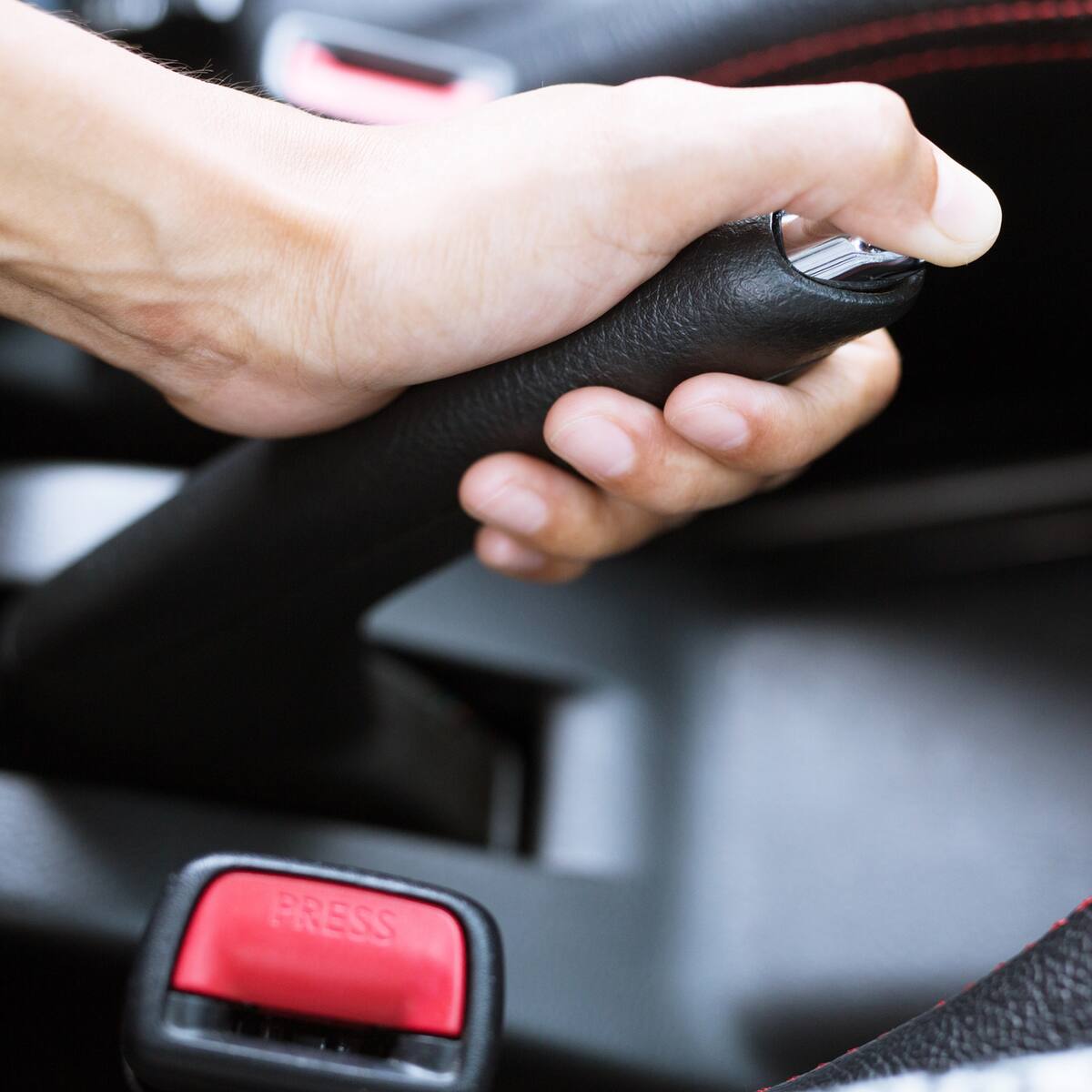 ¿Hay riesgos en accionar el freno de mano de un carro sin oprimir el botón?