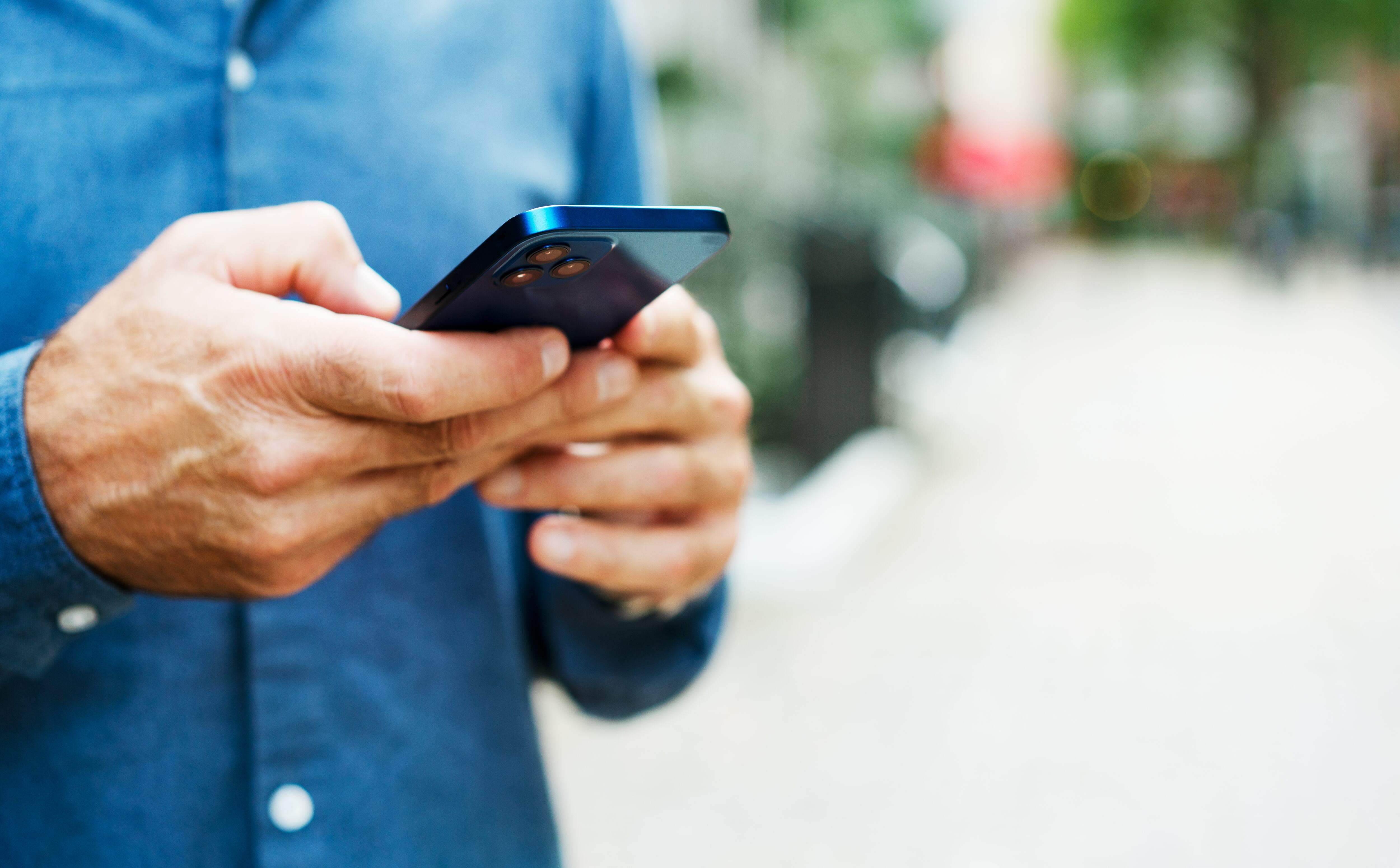 Hombre usando su celular en la calle / FOto: GettyImages
