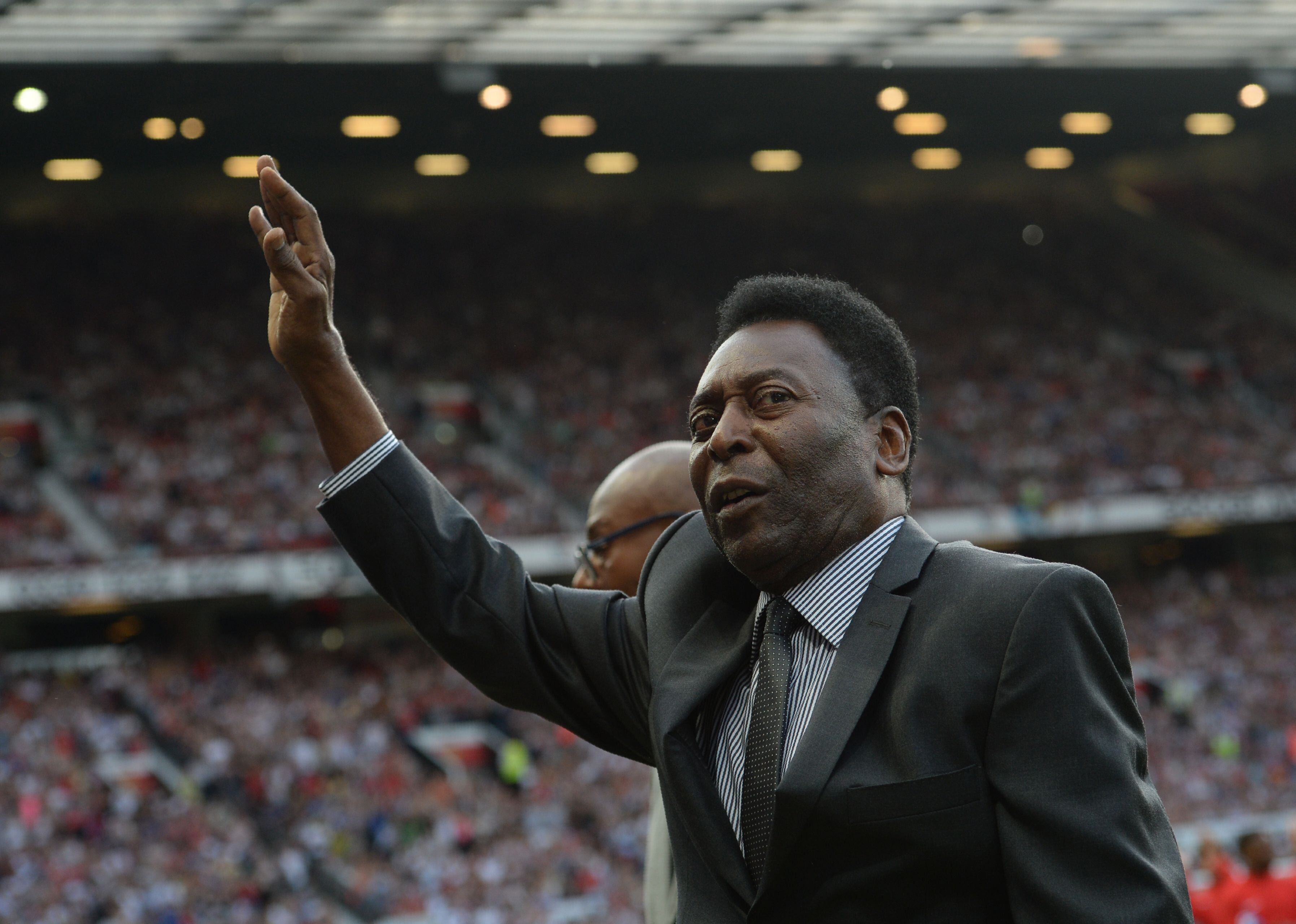 El ex futbolista brasileño Pelé saluda a la multitud en el partido de fútbol benéfico Soccer Aid entre Inglaterra y el resto del mundo en el estadio Old Trafford en Manchester el 5 de junio de 2016. Vía Getty Images