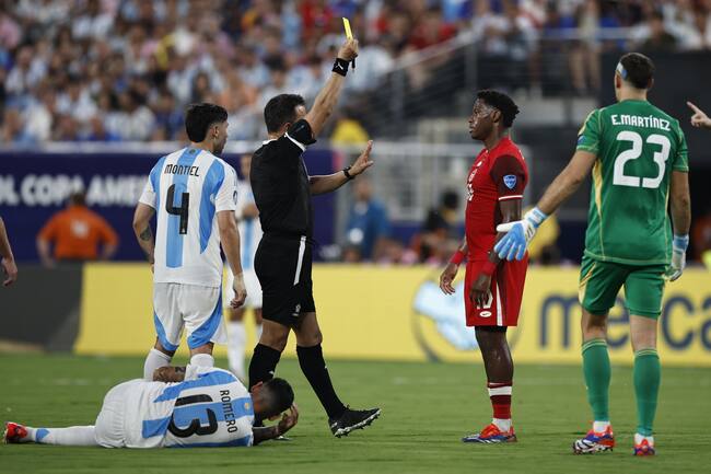 East Rutherford (United States), 10/07/2024.- Referee Piero Maza (3-L) holds up a yellow card on Jonathan David of Canada (2-R) for a foul on Cristian Romero of Argentina (bottom) during the CONMEBOL Copa America 2024 Semi-finals match between Argentina and Canada, in East Rutherford, New Jersey, USA, 09 July 2024. (Roma) EFE/EPA/CJ GUNTHER