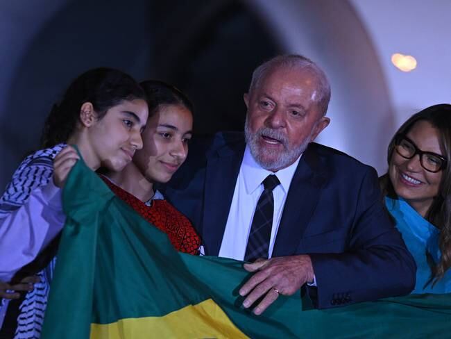 AME6528. BRASILIA (BRASIL), 13/11/2023.- El presidente de Brasil, Luiz Inácio Lula da Silva, recibe a un grupo de personas que estaba atrapado en Gaza y que arribó hoy al país desde Egipto, en Brasilia (Brasil). El grupo de 32 personas, entre brasileños y familiares, llegó este lunes a Brasil después de que las autoridades egipcias les permitieran salir el domingo de la asediada Franja de Gaza y consiguiesen embarcar desde El Cairo. El grupo incluye a 17 menores, nueve mujeres y seis hombres y por nacionalidades 22 son brasileños, siete palestinos naturalizados y tres familiares de nacionalidad palestina. En Brasilia, el grupo permanecerá al menos durante dos días en el hotel de tránsito para militares de la Base Aérea y las personas recibirán apoyo psicológico, atención médica y vacunación. EFE/ Andre Borges