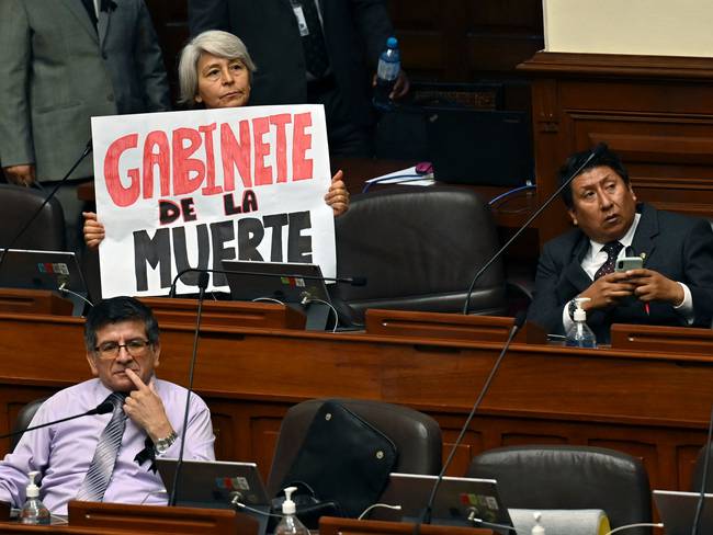 La diputada peruana Margot Agüero, del partido de izquierda Perú Libre, sostiene un cartel que dice &quot;Gabinete de la muerte&quot; durante la sesión plenaria del Congreso, en Lima, el 10 de enero de 2023. -Foto de CRIS BOURONCLE/POOL/AFP vía Getty Images.